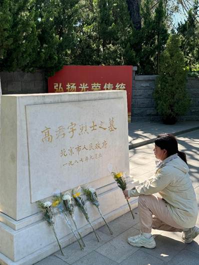 将鲜花轻轻摆放在墓前