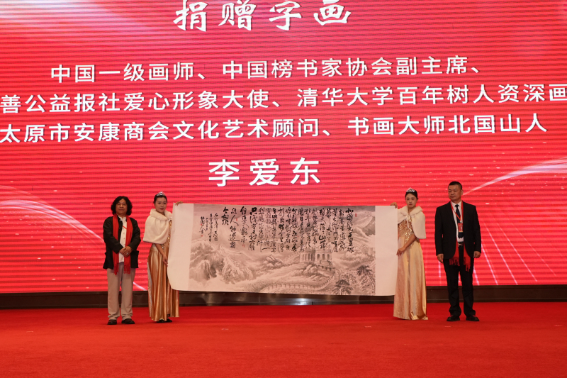 24/12/11中国一级画师、中国榜书家协会副主席、慈善公益报社爱心形象大使、清华大学百年树人资深画家、太原市安康商会文化艺术顾问、书画大师北国山人李爱东（左）为太原市安康商会捐赠字画，太原市安康商会会长张广志（右）接受墨宝。