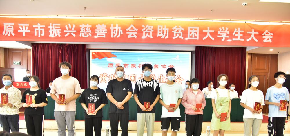 原平市振兴慈善协会副会长爱心人士邢秋勇和受助学生在一起